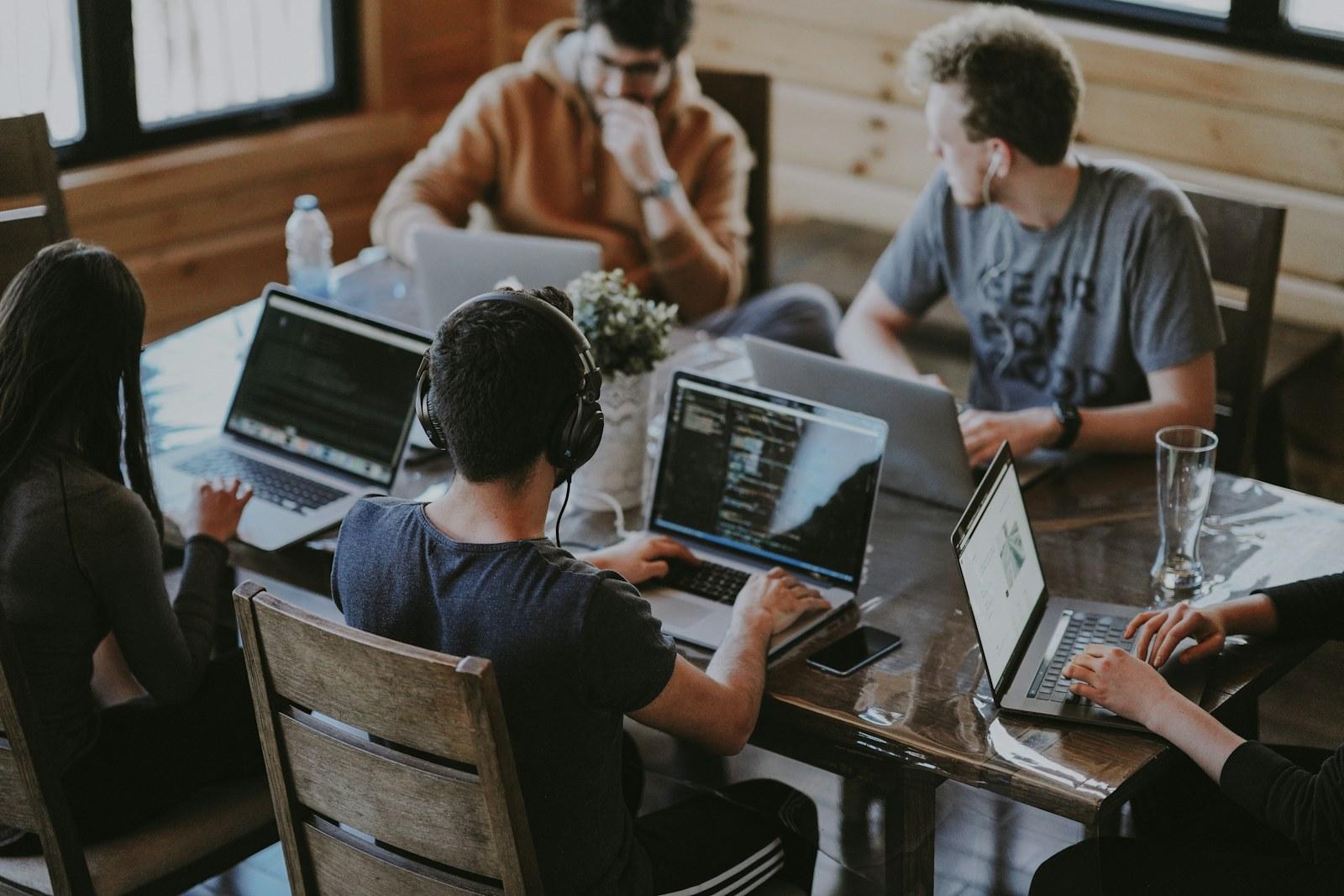 Software team collaborating around a laptop