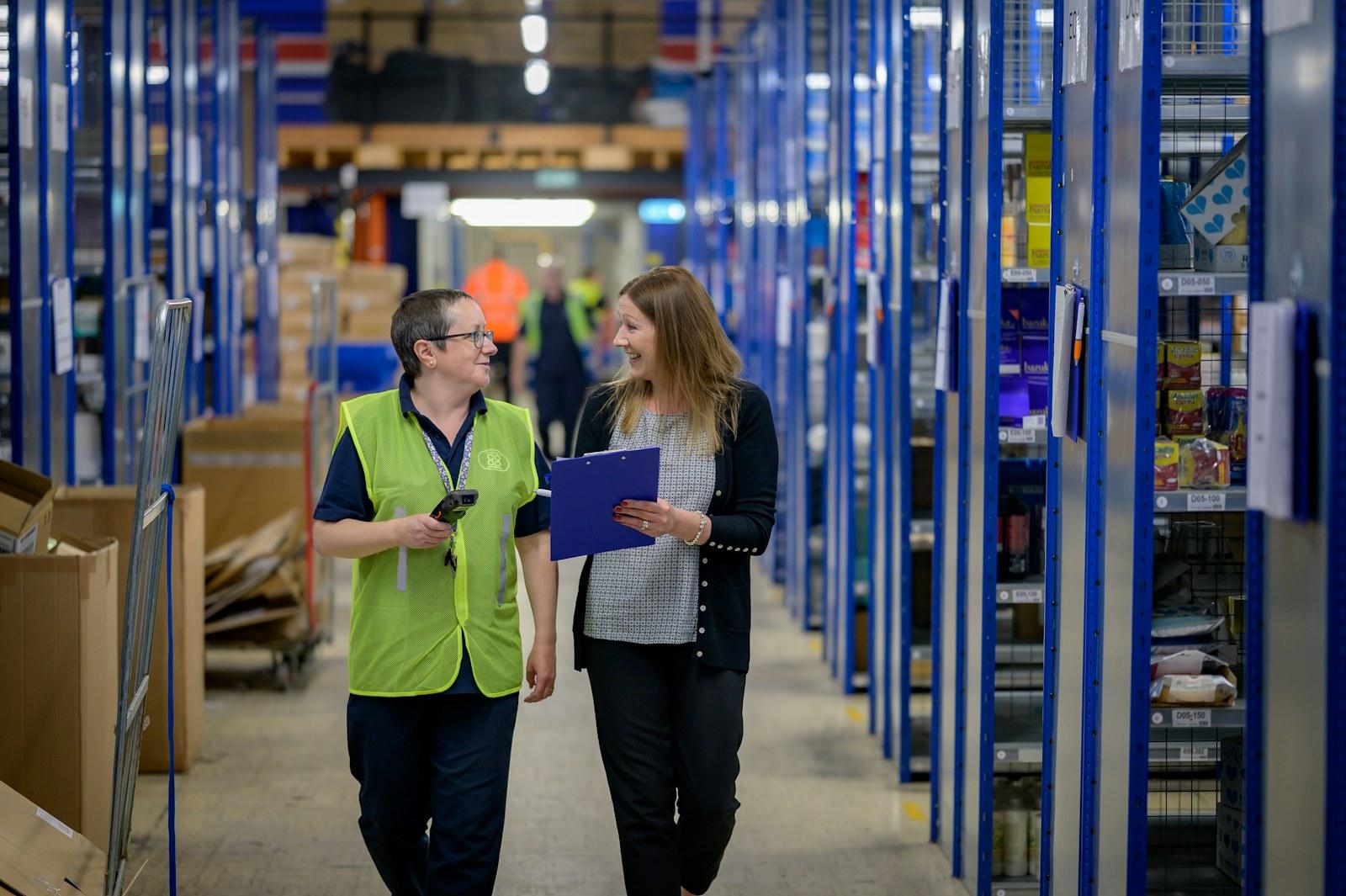 Workers walking through a warehouse storage aisle