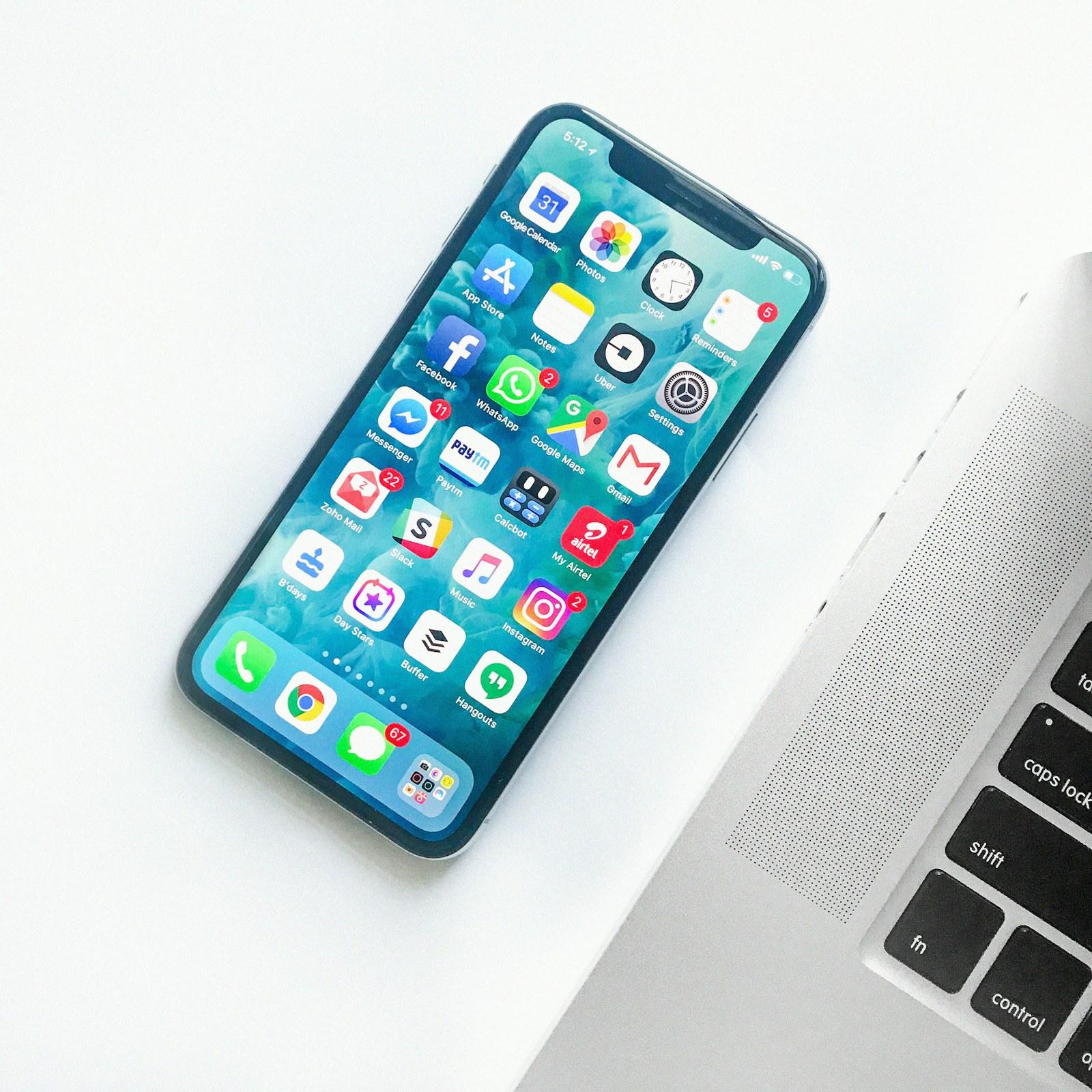 Smartphone with an app interface beside a laptop