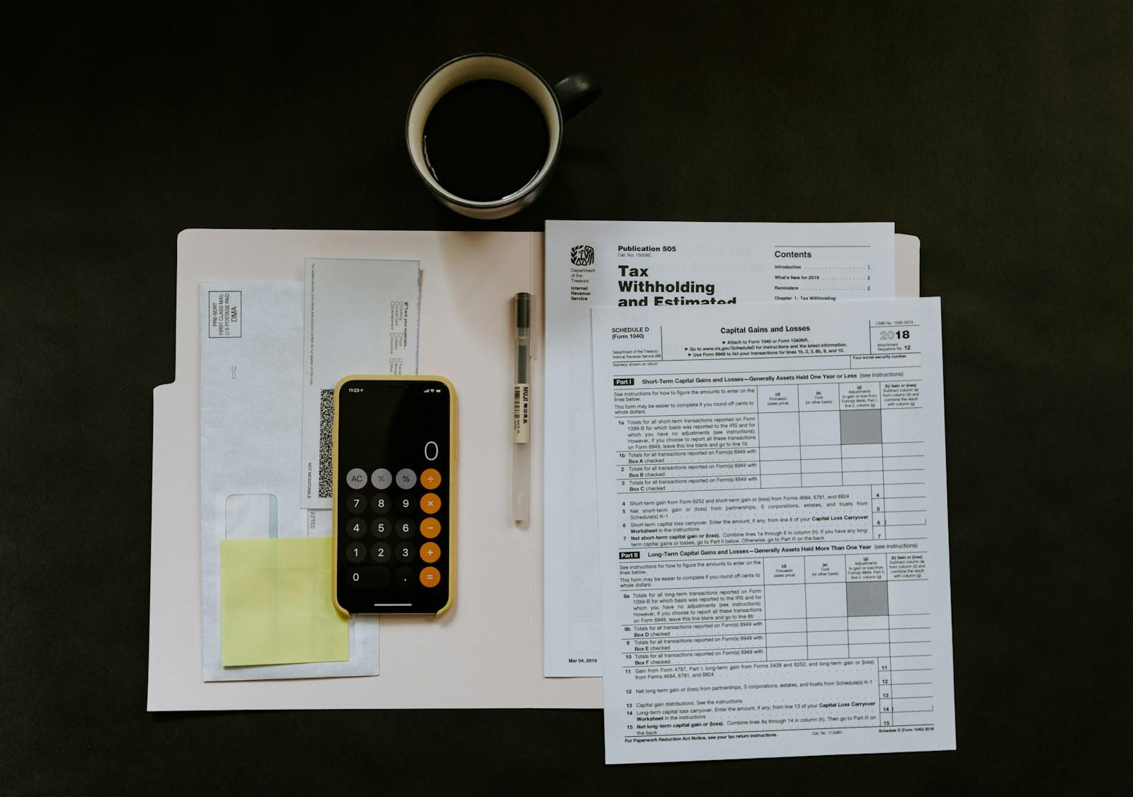 Phone, pen and financial paperwork on a desk