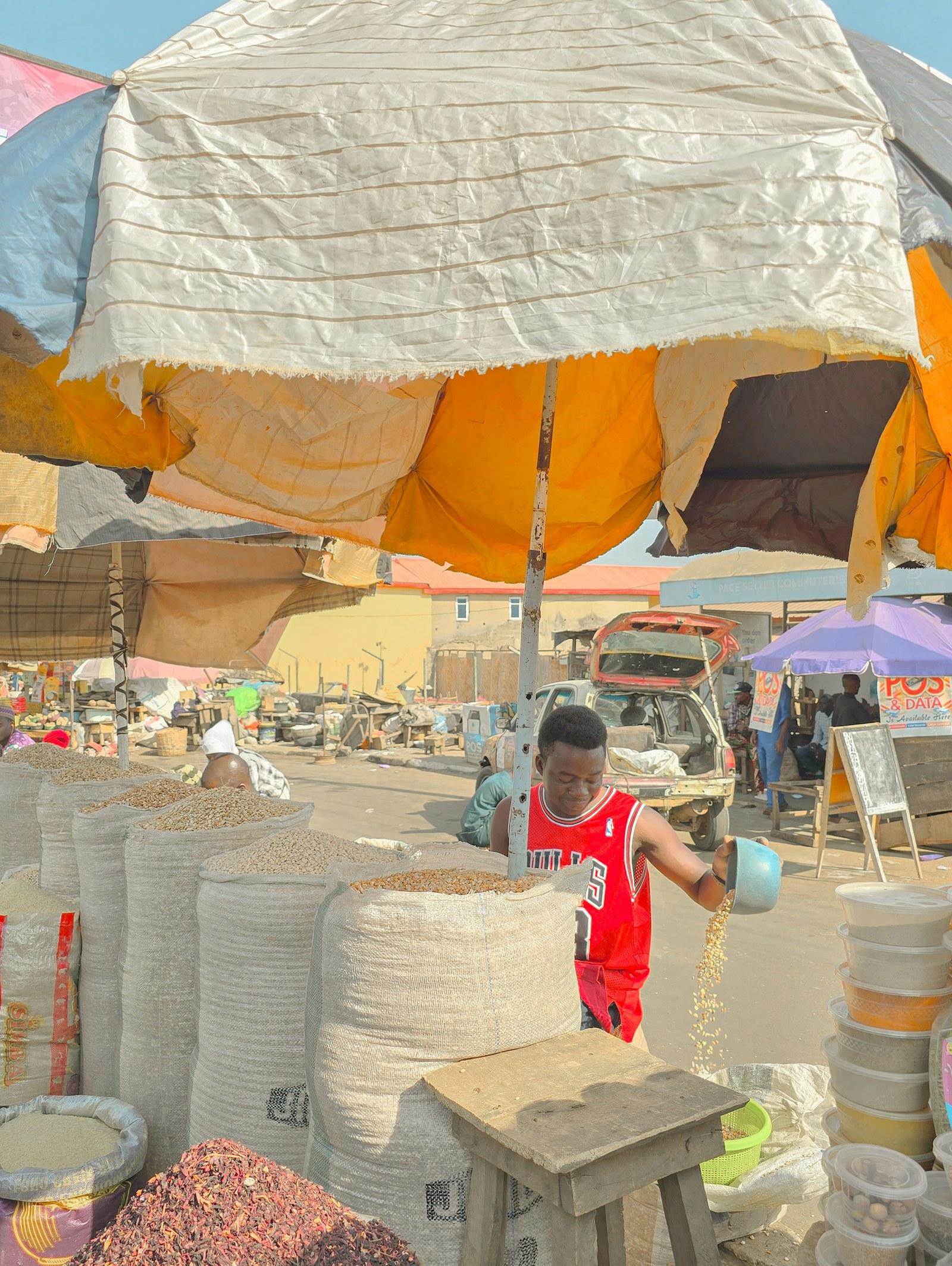 Seller standing under an umbrella at a market