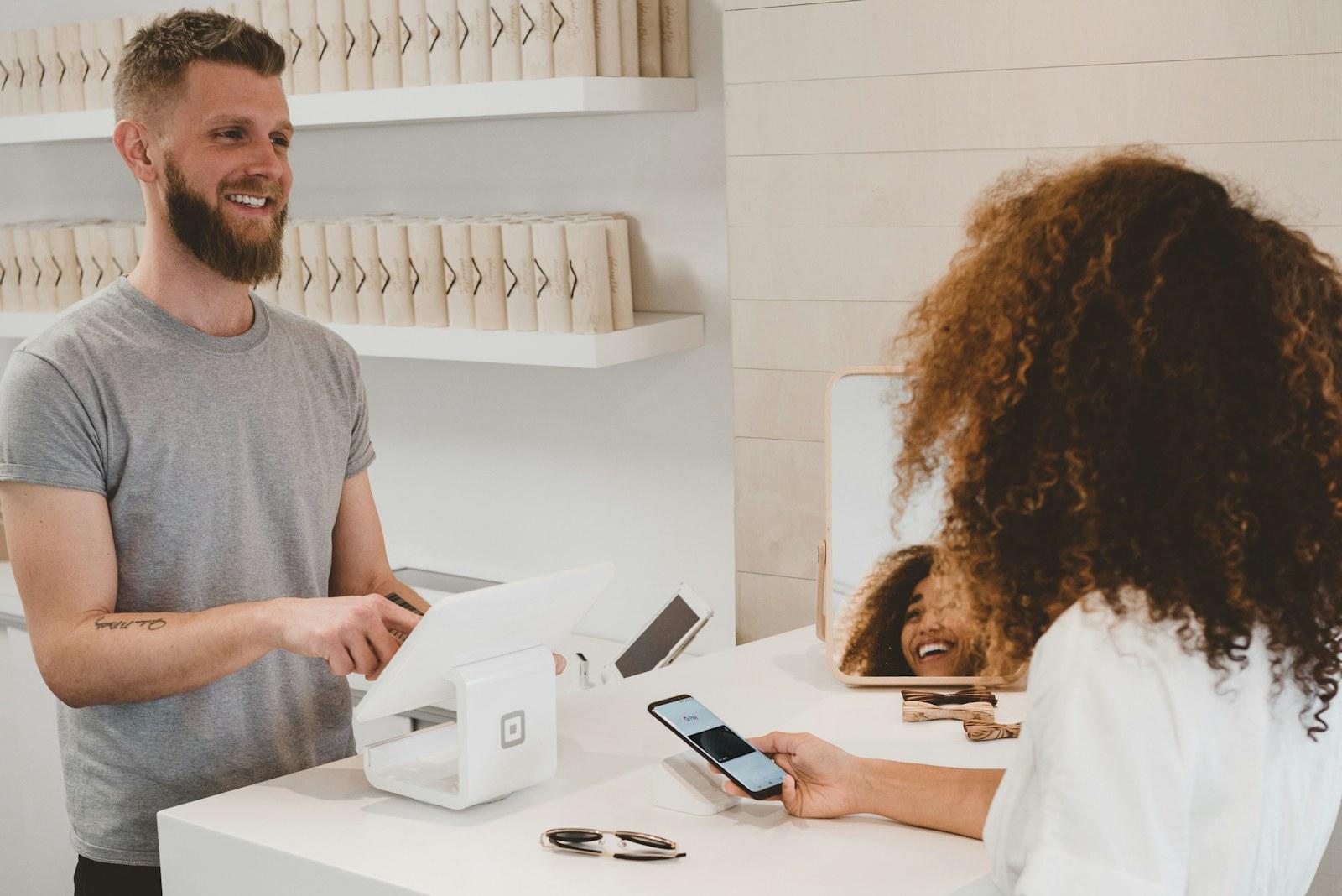 Retail staff serving a customer at a counter